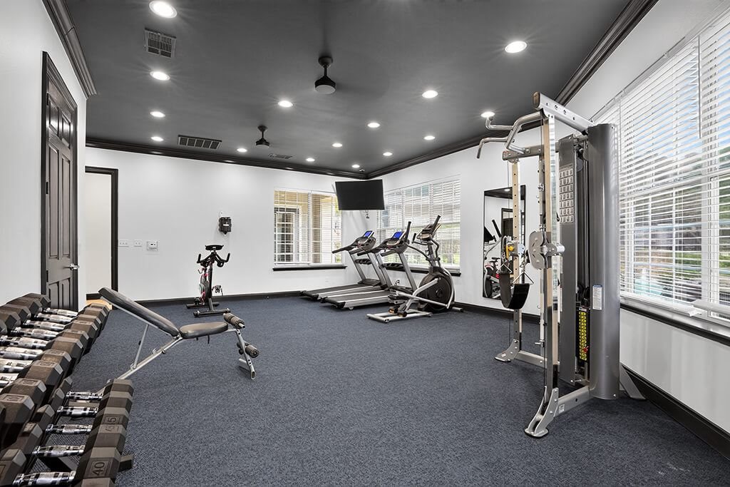 A gym with a variety of equipment including weights and machines.